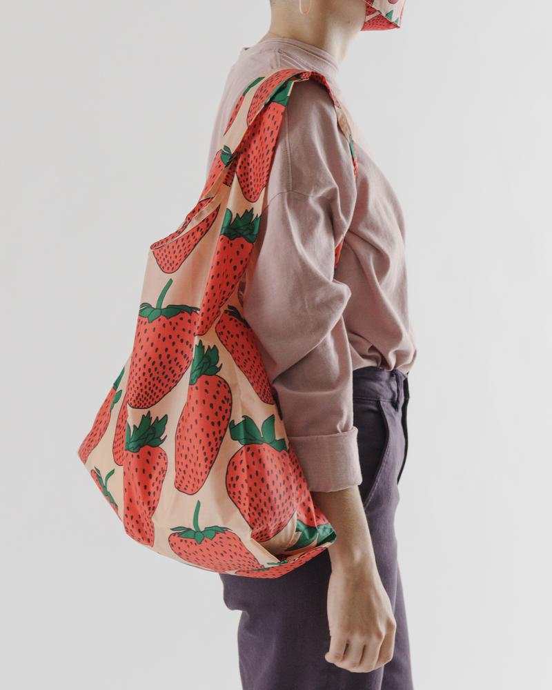 baggu reusable bag strawberry being carried over shoulder