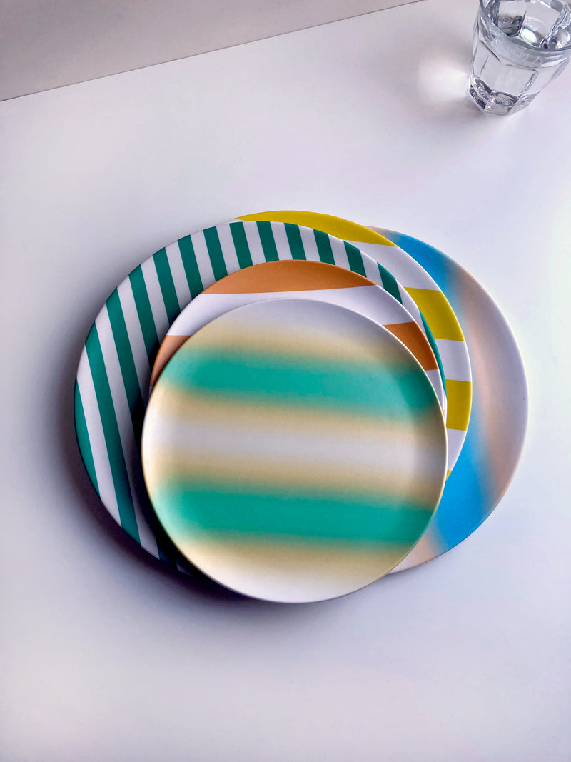dinner and side bamboo plates stacked onto of each other in different striped coloured patters