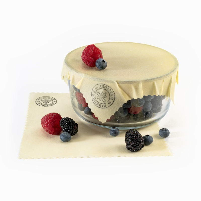 beeswax wrap covering glass bowl with berries inside