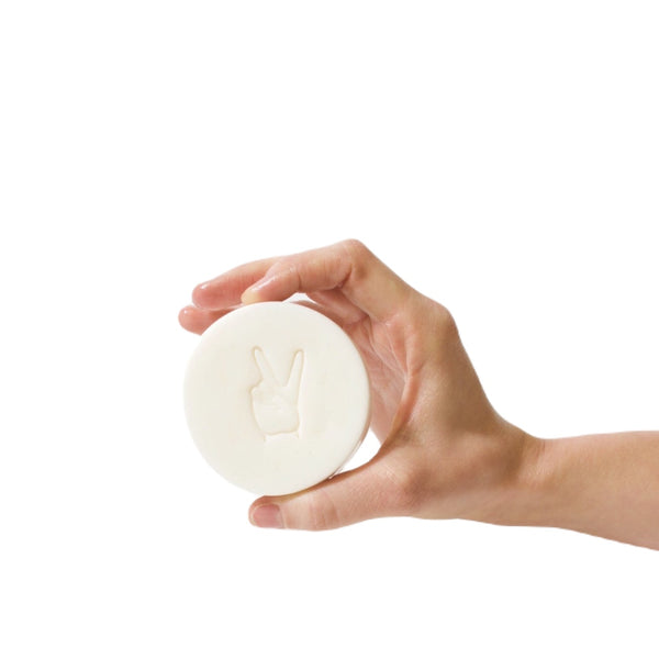 hand holding white facial cleansing bar