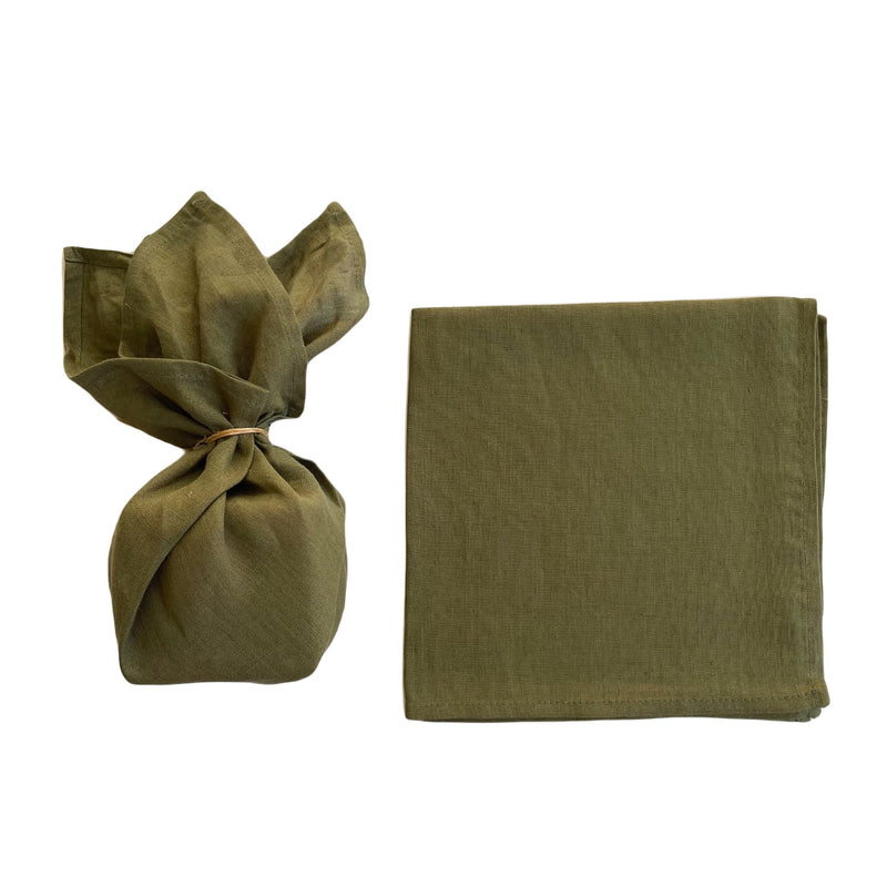 moss coloured linen furoshiki wrapped gift next to flat piece of linen