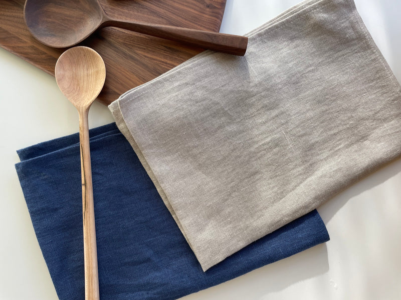 linen teat towels with wooden spoons on table