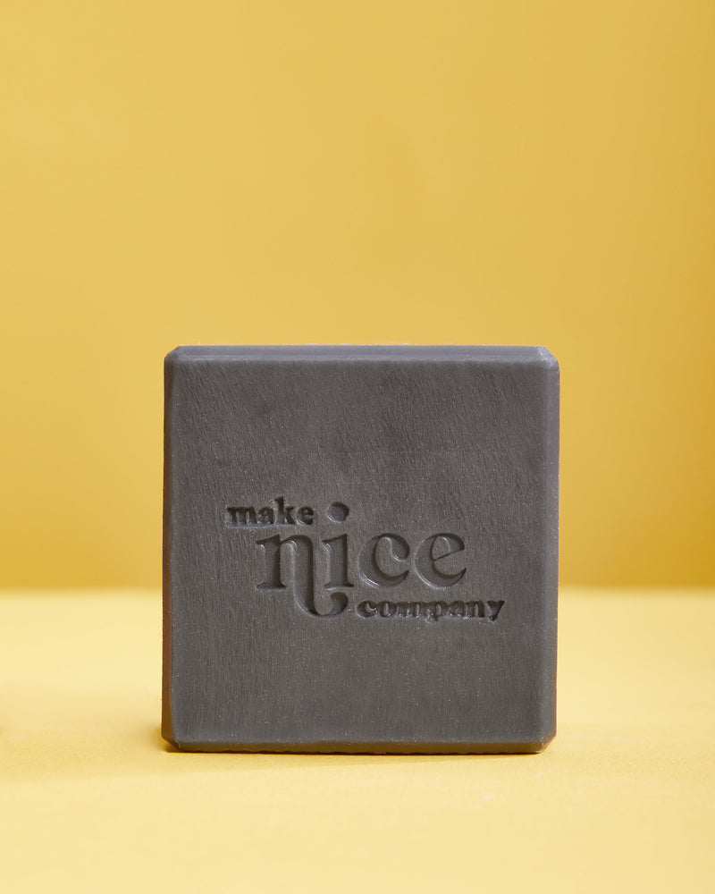 make nice company solid charcoal dish soap block against yellow background