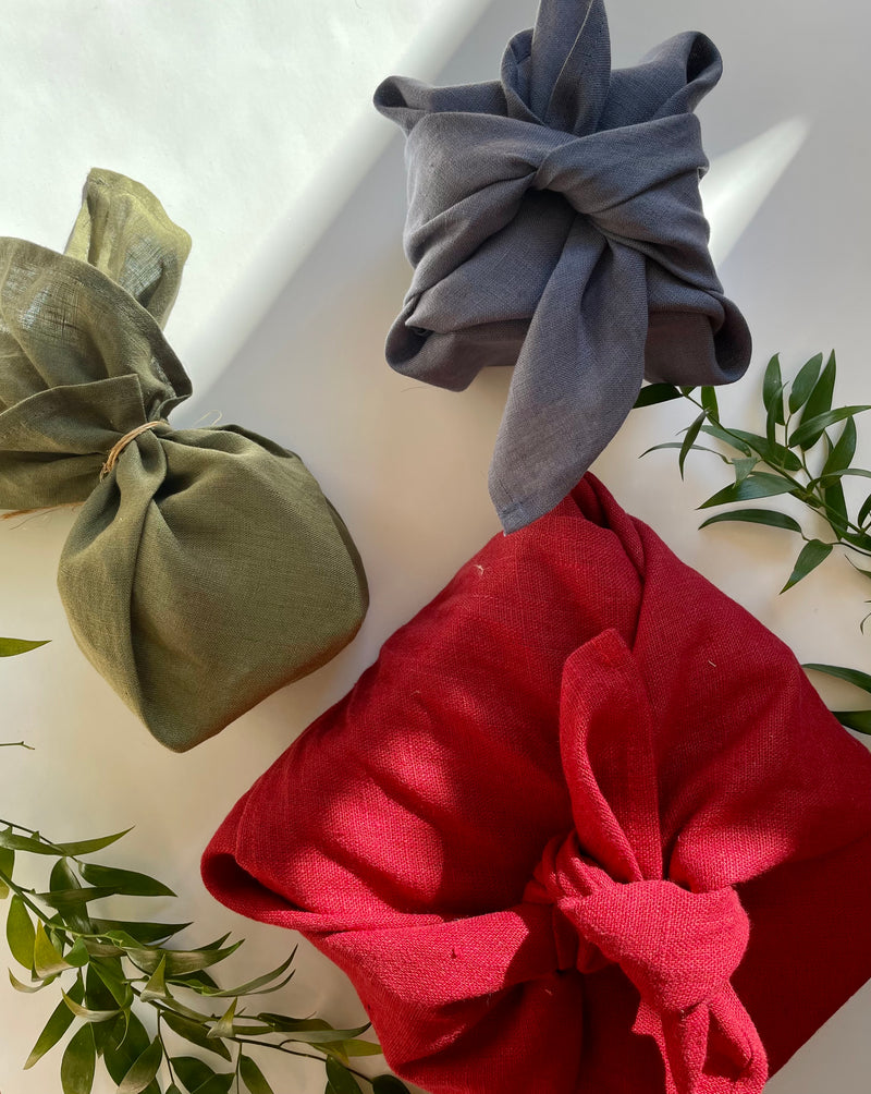 linen furoshiki wraps in red, moss and stone linen fabric with boxes wrapped in them