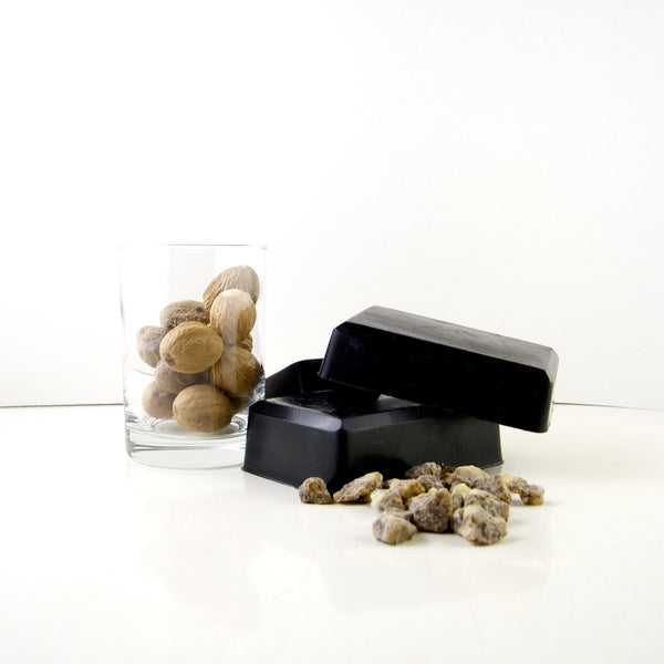 charcoal frankincense black body soap bars stacked next to frankincense crystals on counter and in a glass jar on the side