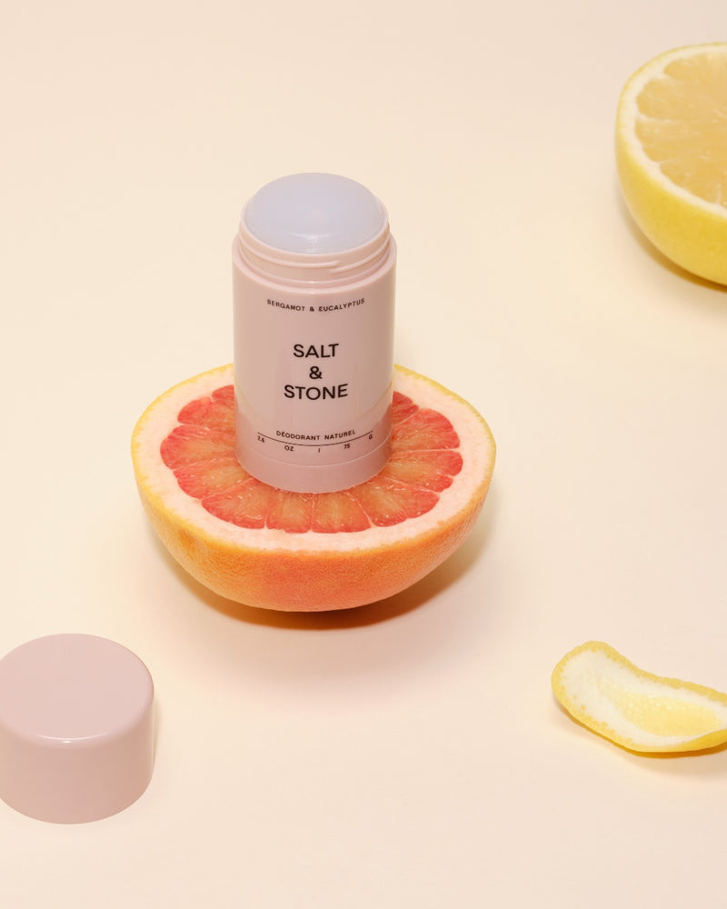 salt and stone natural eucalyptus and bergamot deodorant open onto of a grapefruit and lid on the side
