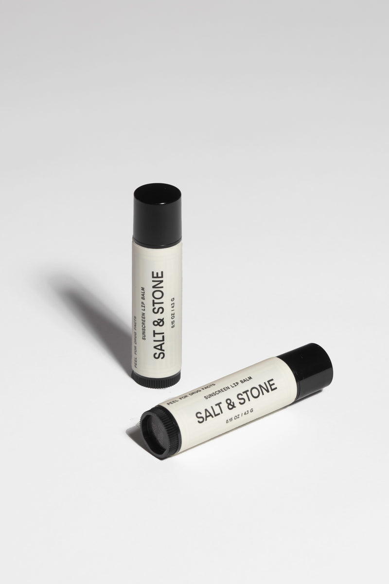 salt and stone sunscreen lip balm standing up right and one laying down