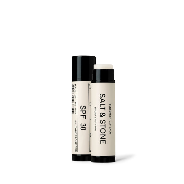 salt and stone spf 30 sunscreen lip balm standing side by side  one with lid off
