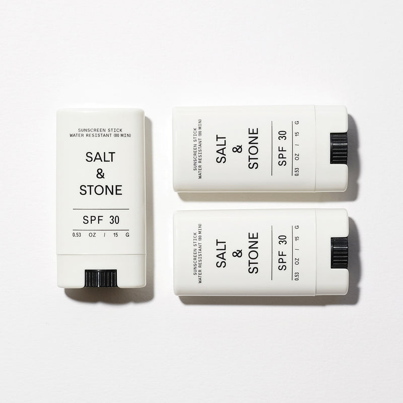 three salt ands tone sunscreen face sticks laid on white background