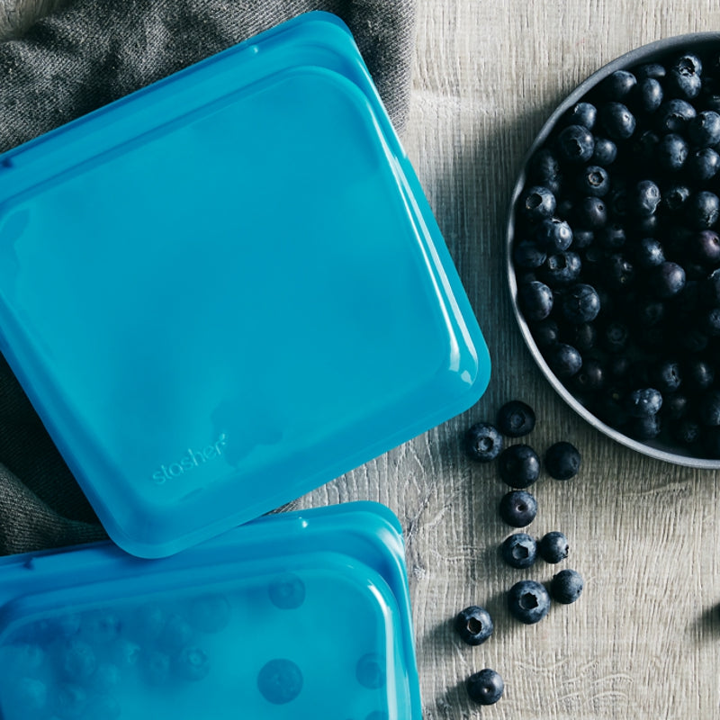 blue stasher sandwich bag on counter with bowl of blueberries