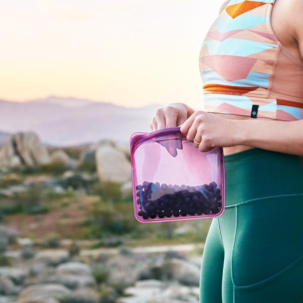 woman outside holding stasher sandwich bag dusk with blueberries inside