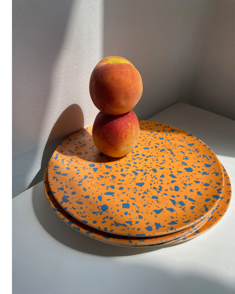 bamboo orange terrazzo side plates stacked with peaches on top
