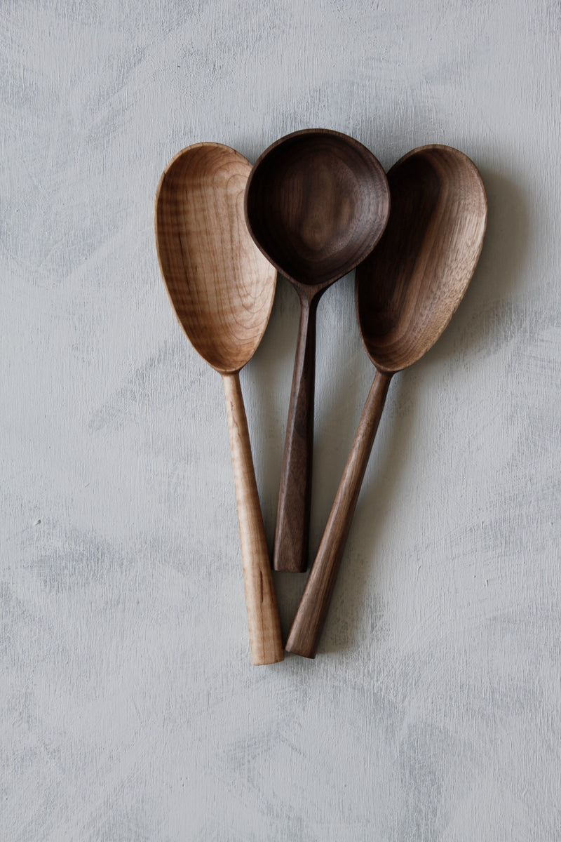 woodsmans daughter two hardwood oval serving spoons laid with round walnut serving spoon in between